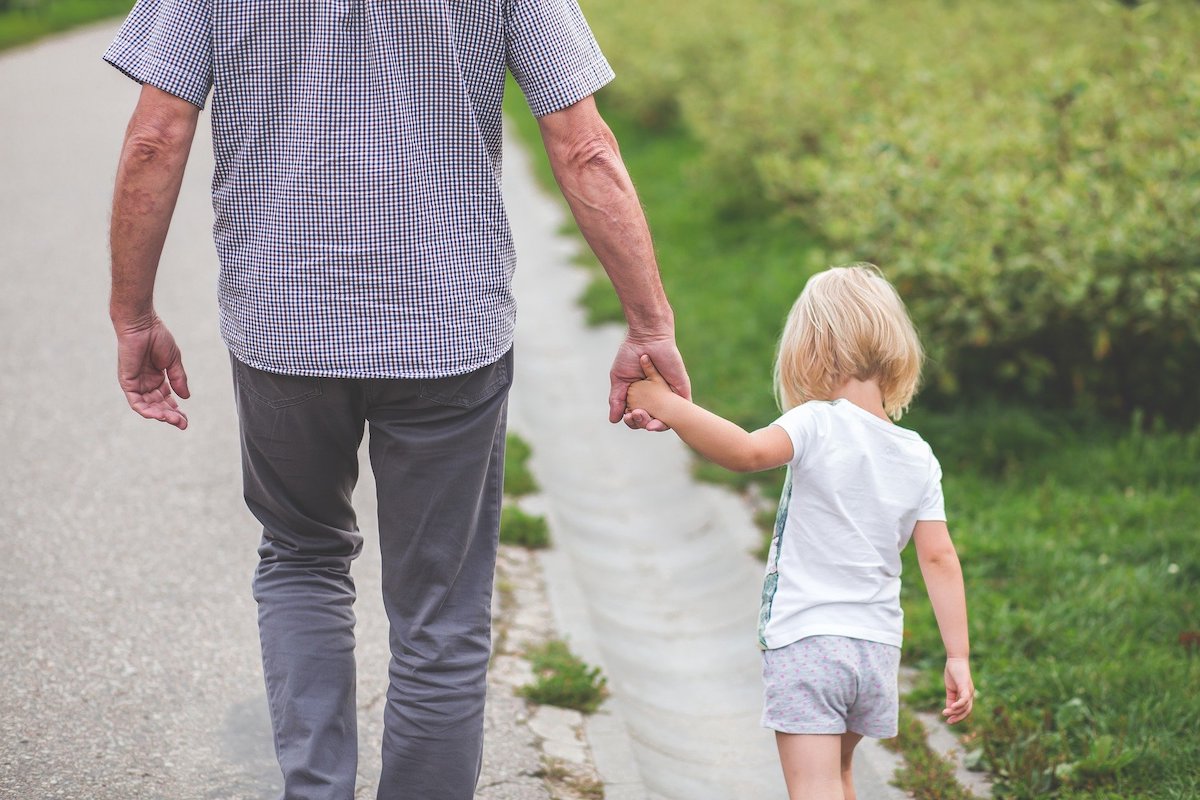 A person with a kid holding hands